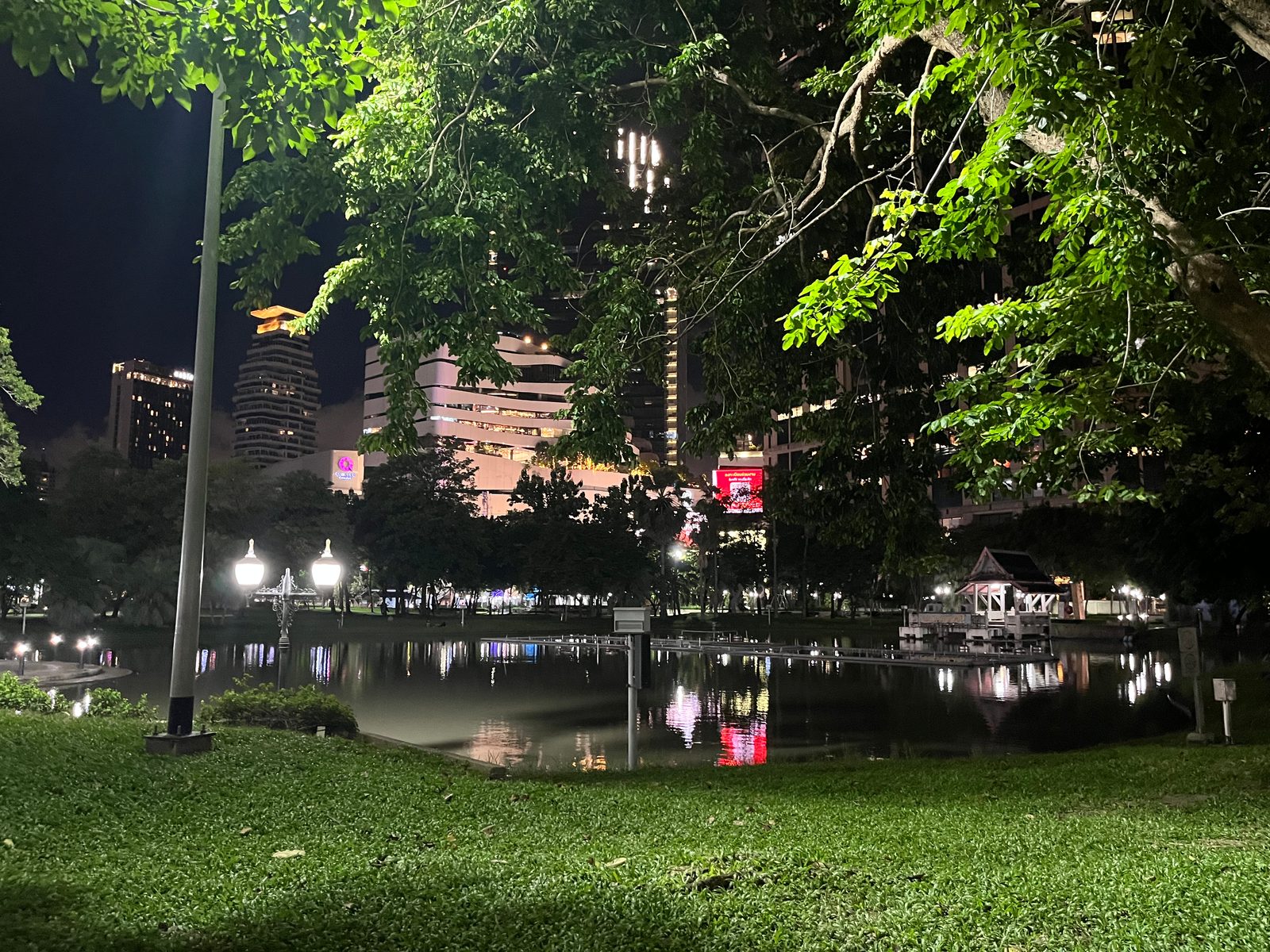 The lake in Benjasiri Park at night, with lit towers reflected in the water