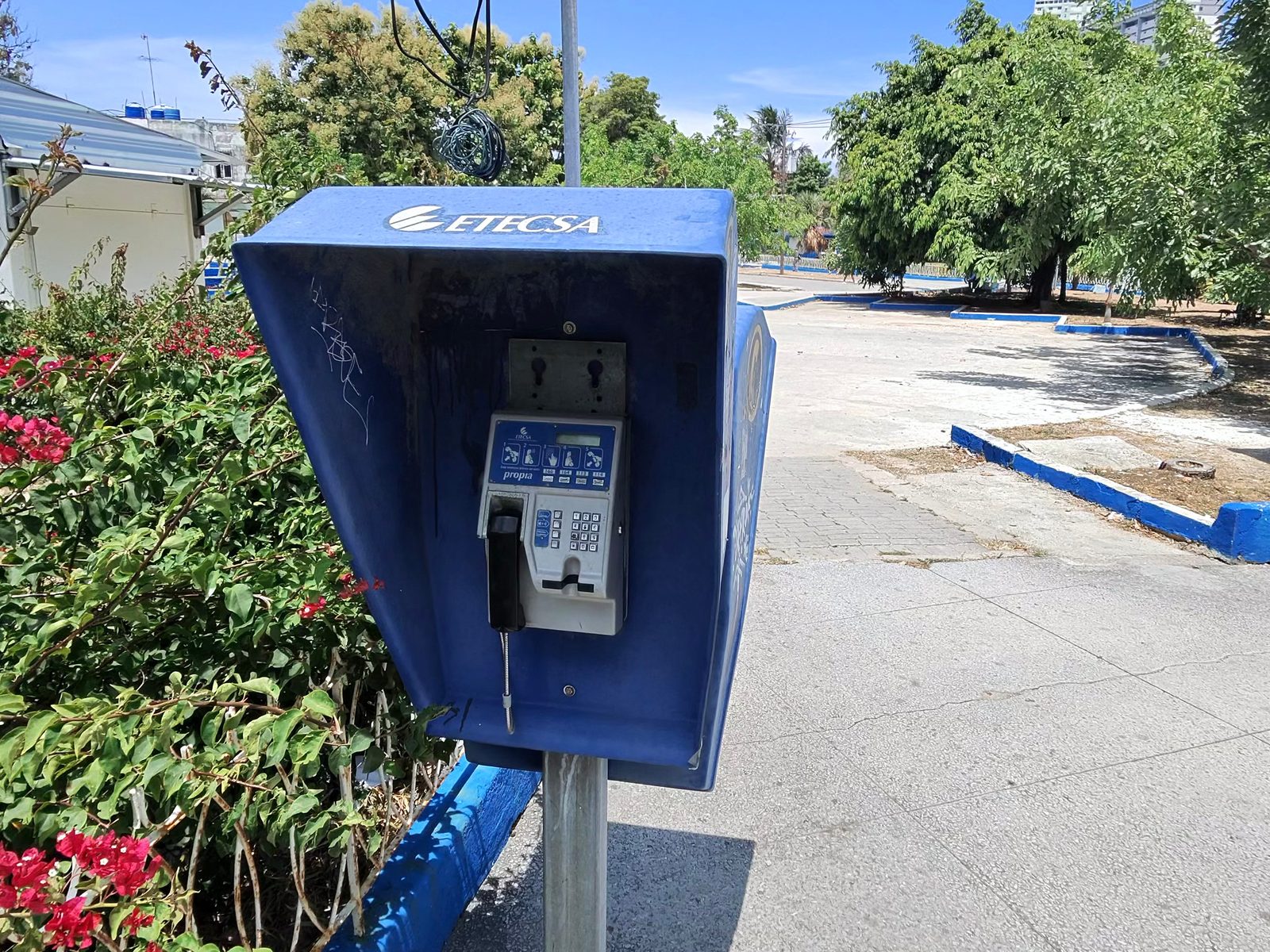 A blue ETECSA payphone booth on a Vedado sidewalk