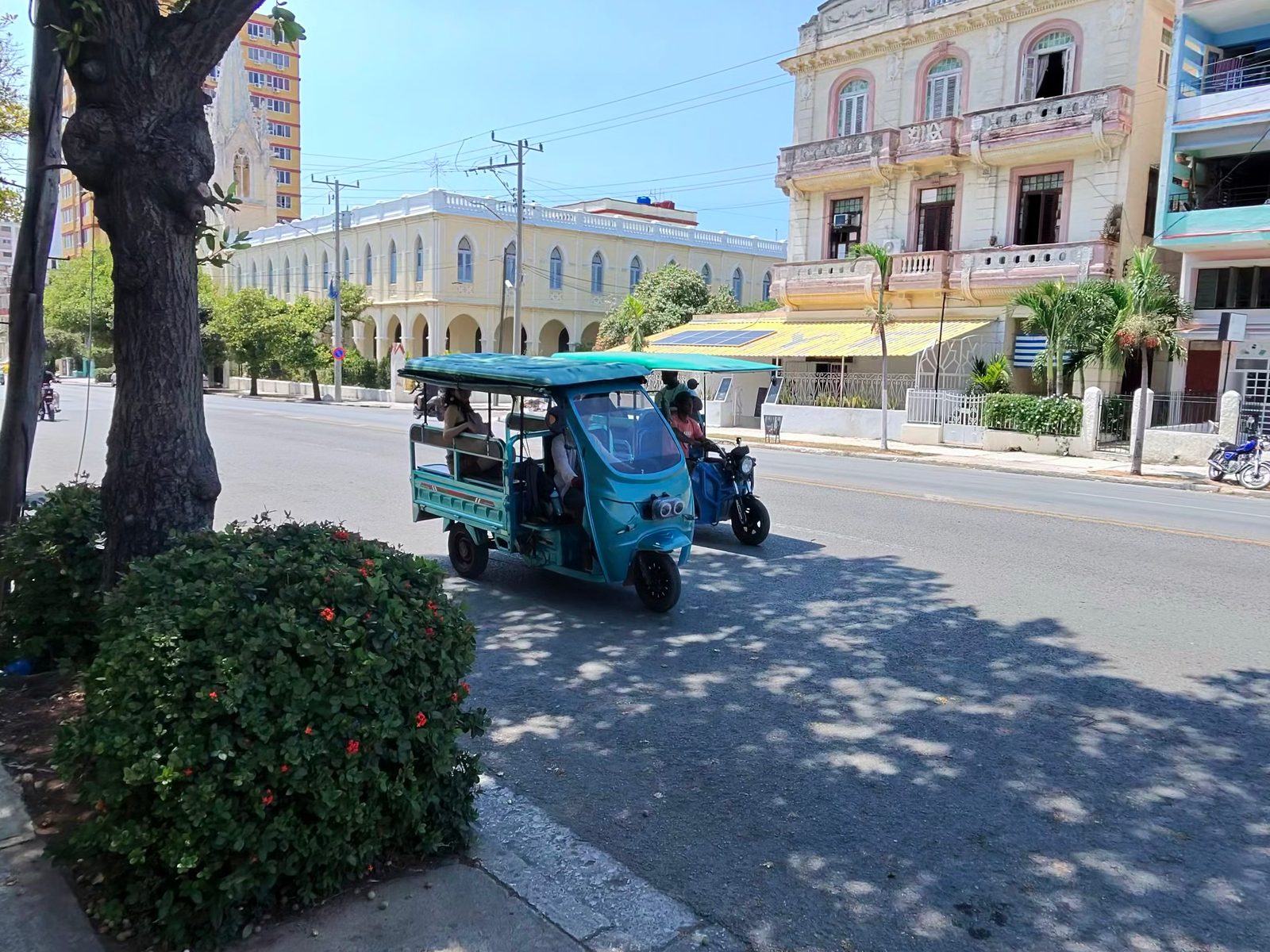 An electric tricycle taxi on a shaded Vedado street
