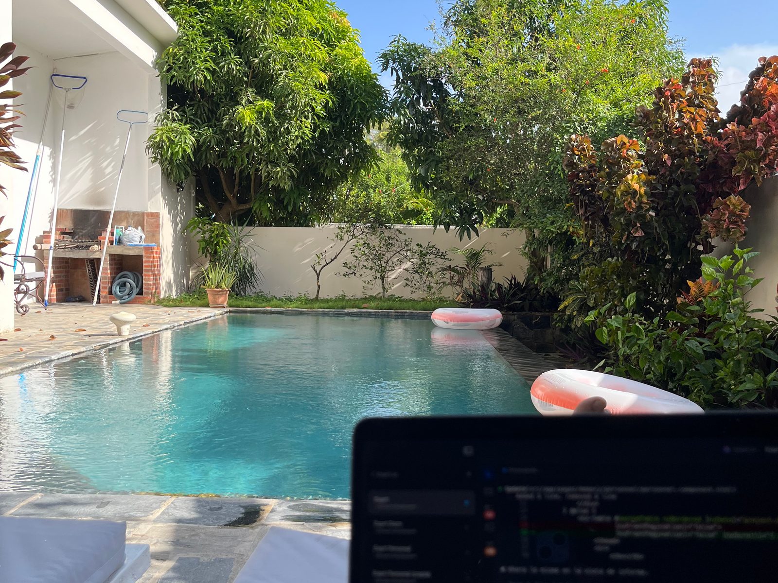 Pool in the garden of a rental in Las Terrenas, with a laptop open in the foreground