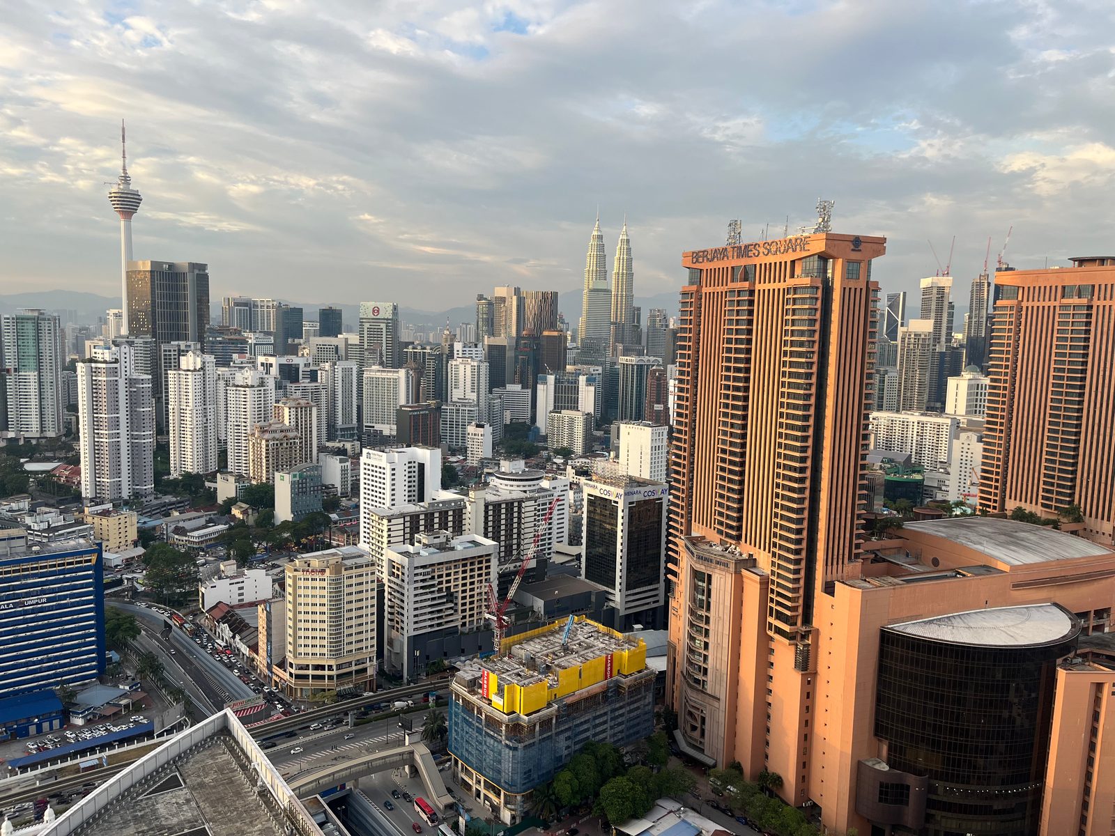 Kuala Lumpur condo towers seen from a high floor, with KL Tower and the Petronas Towers behind