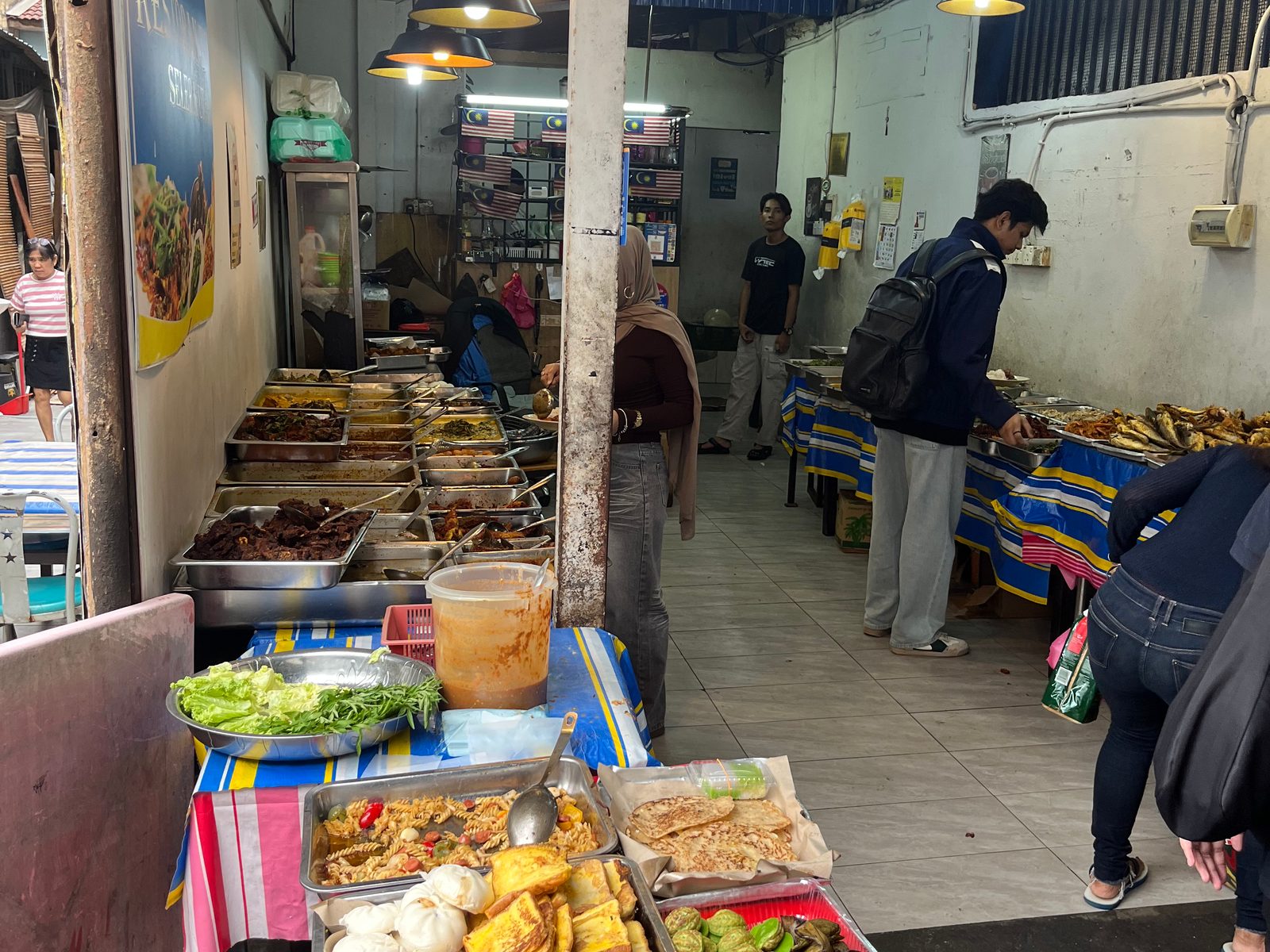 Trays of fried snacks, vegetables and curries at a local food stall in Kuala Lumpur