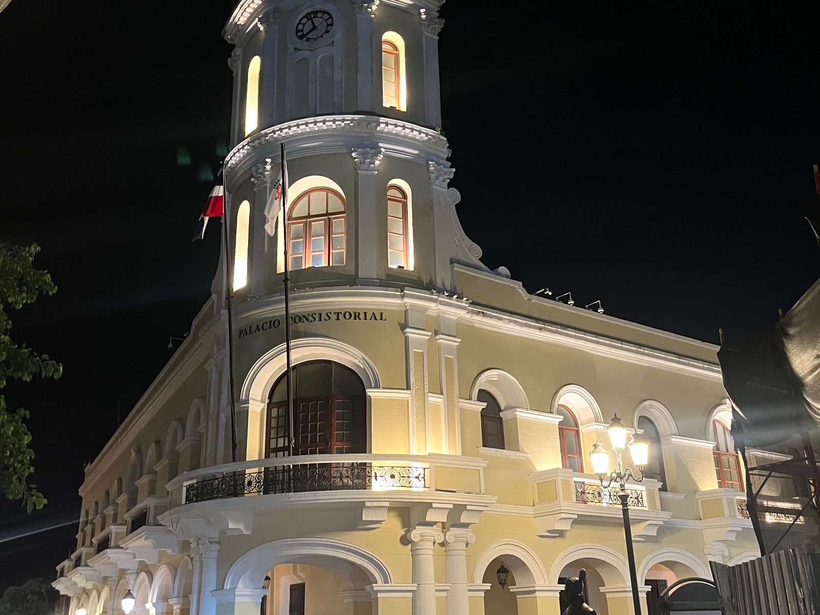 The Palacio Consistorial clock tower lit up at night in the Zona Colonial