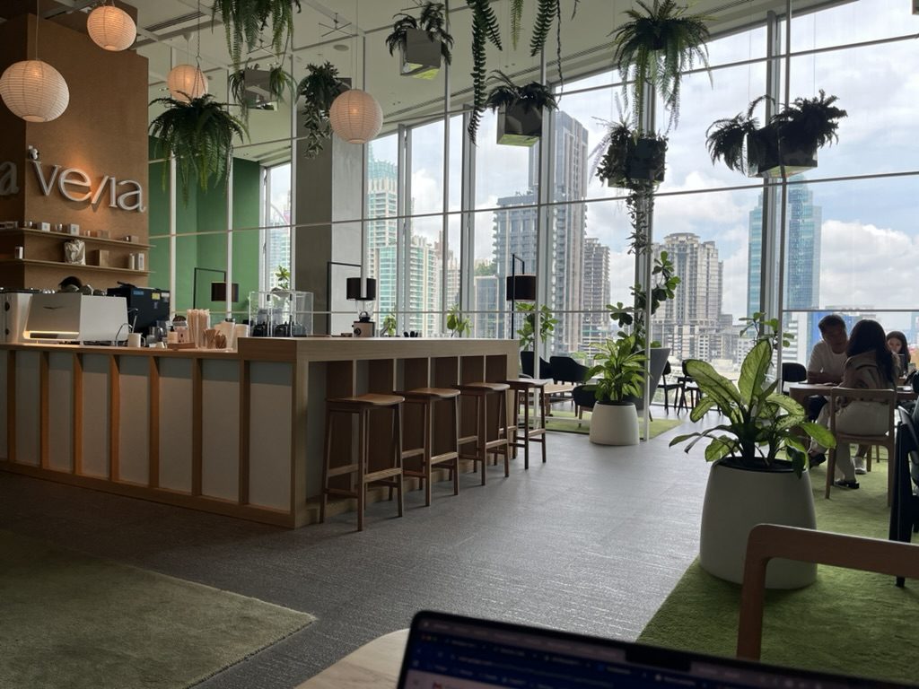 A bright plant-filled work café with skyline views in Bangkok