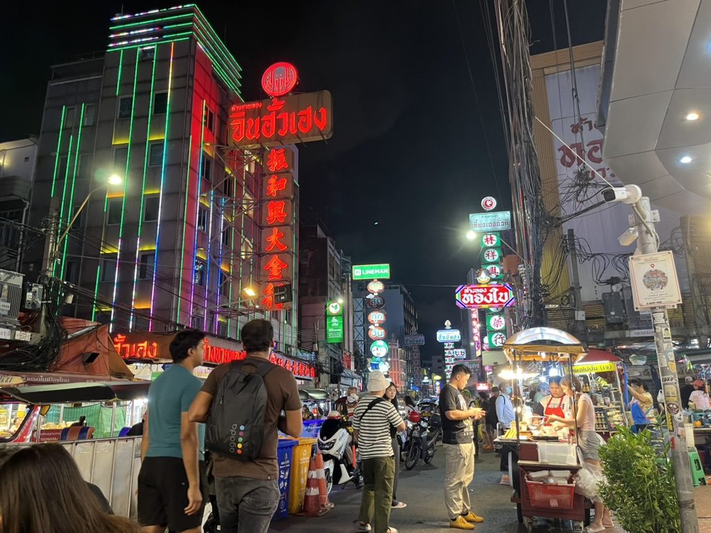 Chinatown street at night with neon signs and food stalls in Bangkok