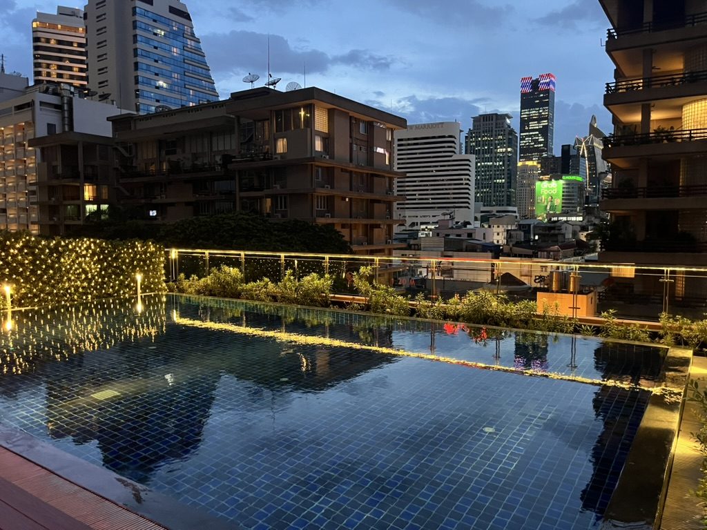 Bangkok skyline at dusk from a rooftop pool
