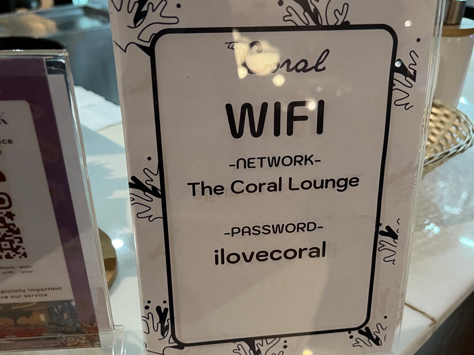 A table sign with the WiFi network and password of an airport lounge at Don Mueang
